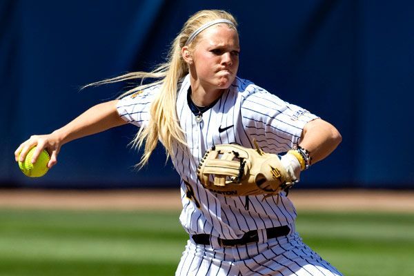 Softball player in pinstripes making a throw