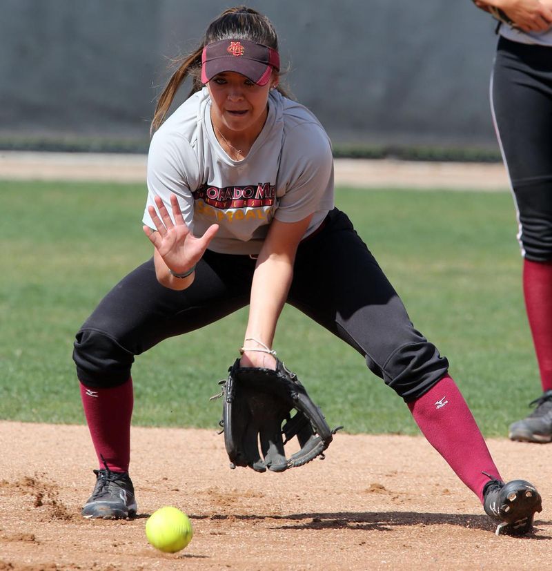 Softball infielder fielding a ground ball with her glove down